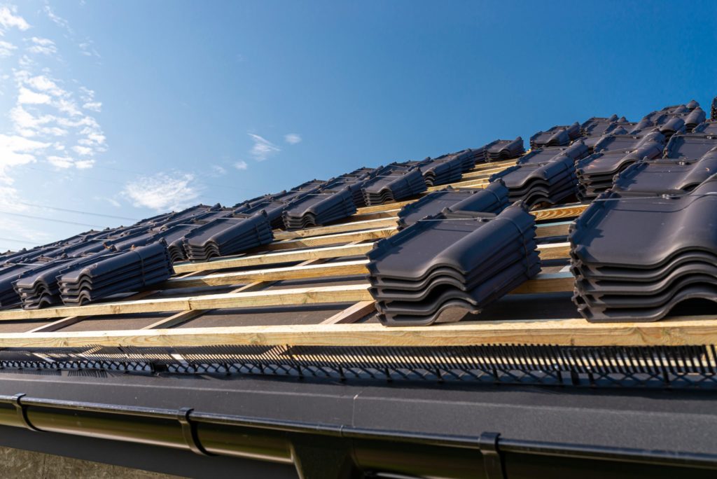 Roof ceramic tile arranged in packets on the roof on roof battens. Preparation for laying roof tiles