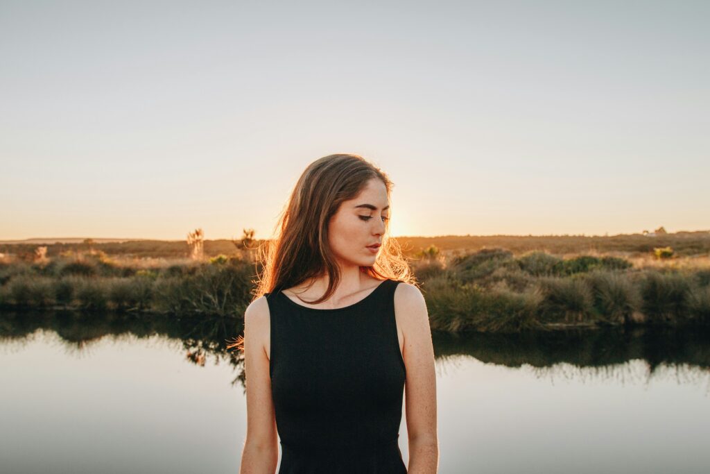 a woman standing in front of a body of water