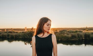 a woman standing in front of a body of water
