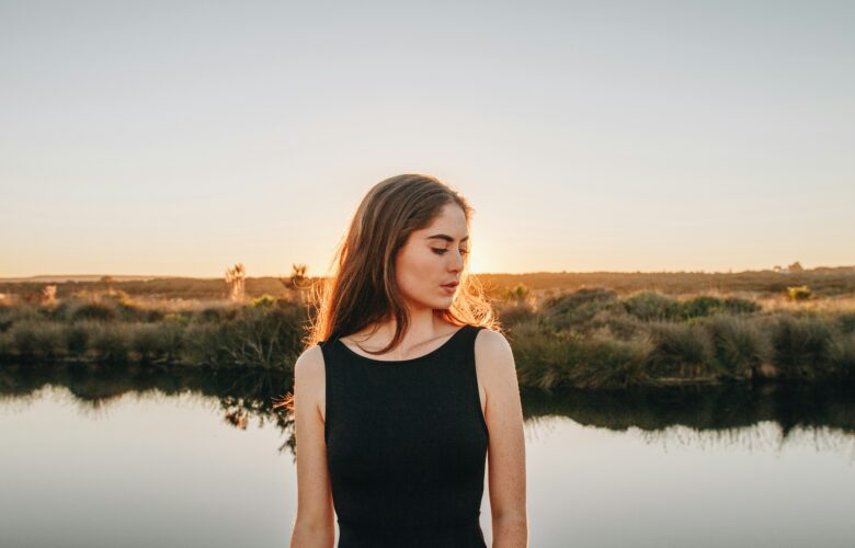a woman standing in front of a body of water